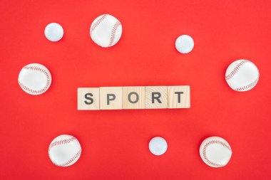 sport lettering on wooden cubes near softballs isolated on red  clipart