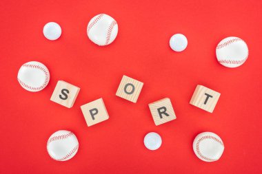 sport letters on wooden cubes near softballs isolated on red  clipart