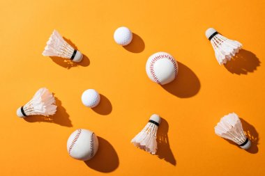 top view of shuttlecocks with feathers near softballs and golf balls on yellow  clipart