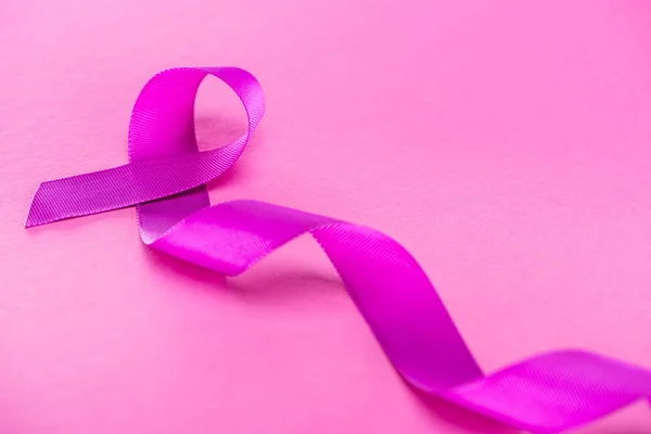 ピンクの背景に長い紫色のリボン — ストック写真