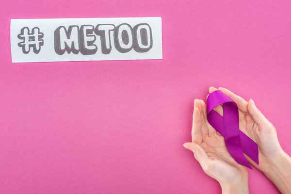 cropped view of woman holding purple awareness ribbon near paper with hashtag me too isolated on pink