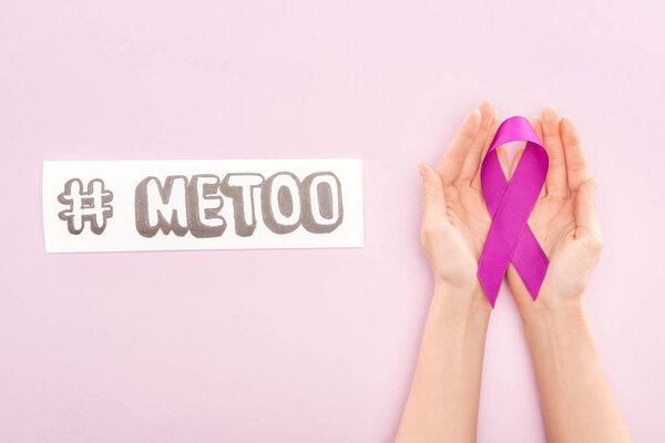 cropped view of purple awareness ribbon on hands of woman near paper with hashtag me too isolated on light pink 