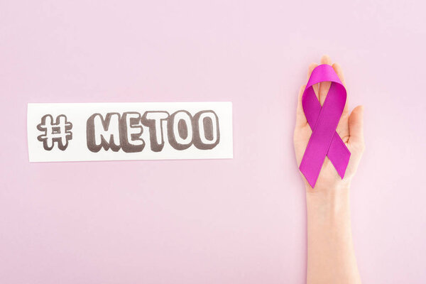 cropped view of purple awareness ribbon on hand of woman near paper with hashtag me too isolated on pink
