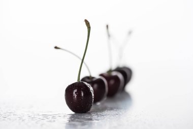 selective focus of red, whole and ripe cherries covered with droplets  clipart
