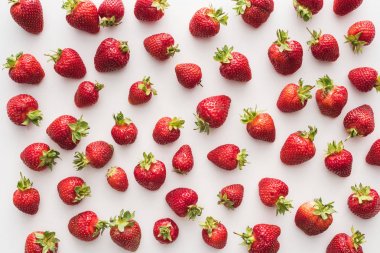 top view of whole and red strawberries on white background  clipart
