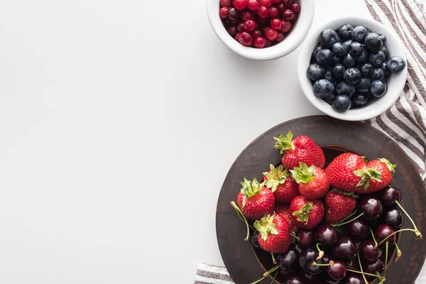 碗上整个小红莓和蓝莓的顶视图 草莓和樱桃在盘子里 — 图库照片