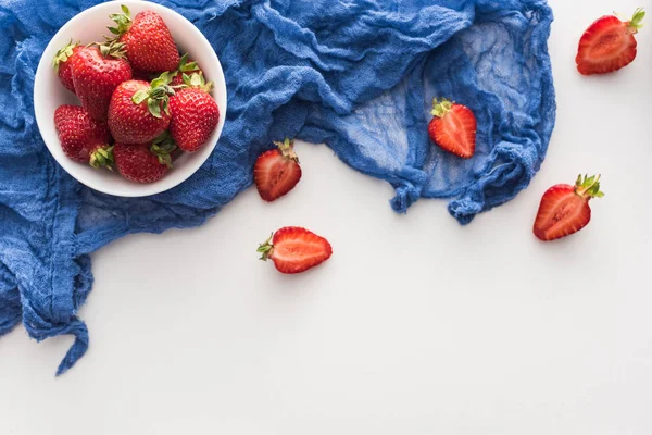 在碗上用蓝布的甜和红草莓的顶视图 — 图库照片