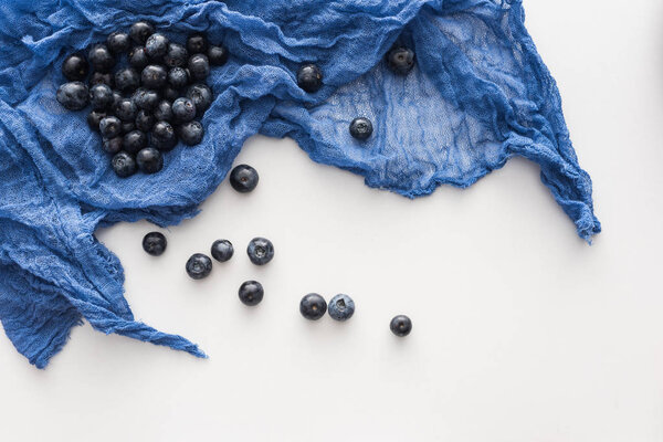 top view of sweet and ripe blueberries on blue cloth 