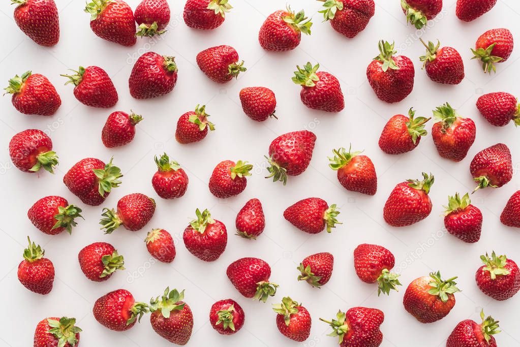 top view of whole and red strawberries on white background 