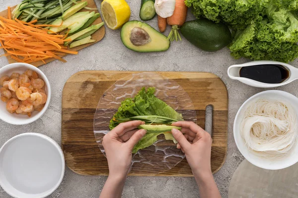 Top View Woman Putting Cut Avocado Lettuce Cutting Board — стоковое фото