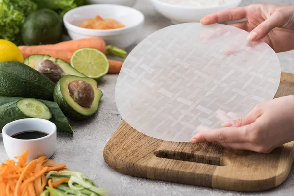 Vista Cortada Mulher Segurando Papel Arroz Entre Ingredientes — Fotografia de Stock