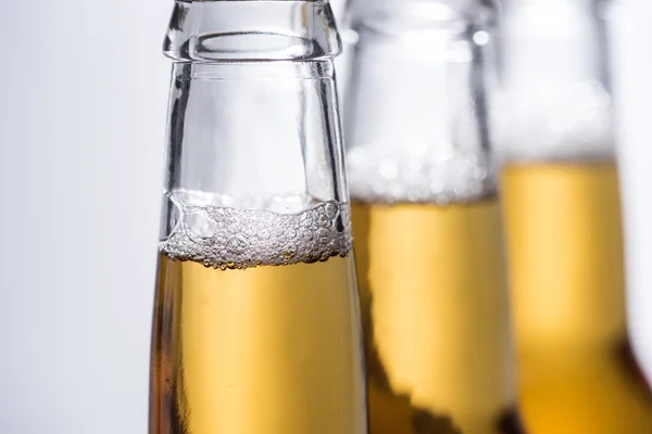 Focus Selettivo Bottiglie Birra Con Bollicine Isolate Sul Grigio — Foto Stock
