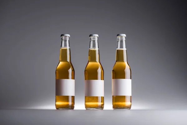 Three Glass Bottles Beer Row White Labels Grey Background — Stock Photo, Image