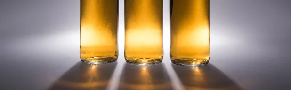 Close Vista Garrafas Cerveja Com Luz Sombra Sobre Fundo Cinza — Fotografia de Stock