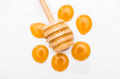 top view of honey drops and wooden honey dipper isolated on white 