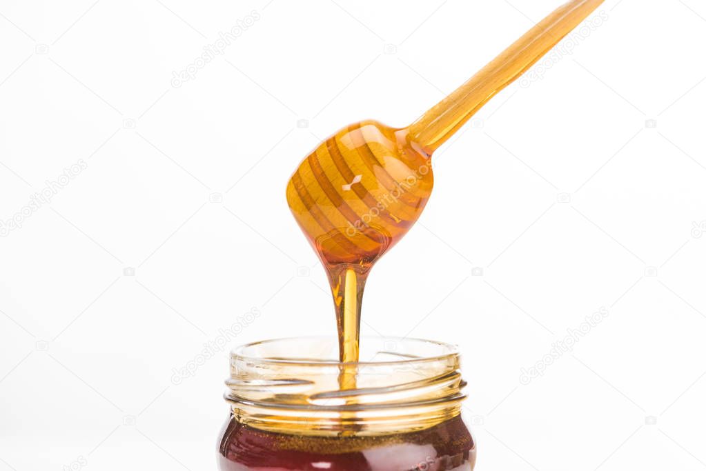 wooden honey dipper with dripping delicious honey isolated on white 