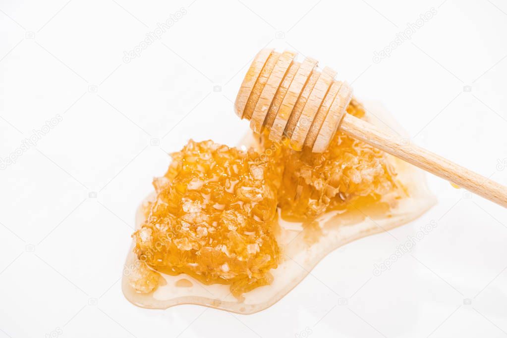 honeycomb with sweet delicious honey and wooden honey dipper isolated on white