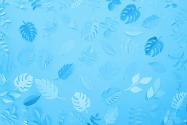 mavi minimalist arka planda kağıt kesme yaprakları üst görünümü