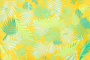 kopya alanı ile sarı parlak arka planda kağıt kesilmiş yeşil tropikal yaprakları üst görünümü