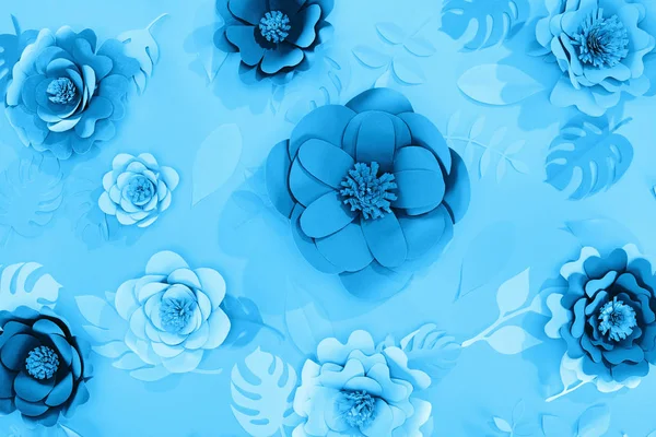 top view of paper leaves and flowers on blue minimalistic background