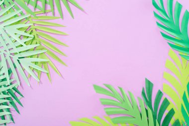 top view of green paper cut tropical leaves on violet background with copy space clipart