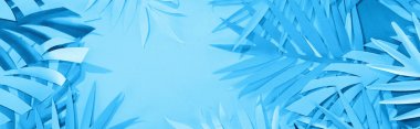 panoramic shot of paper leaves on blue minimalistic background with copy space clipart