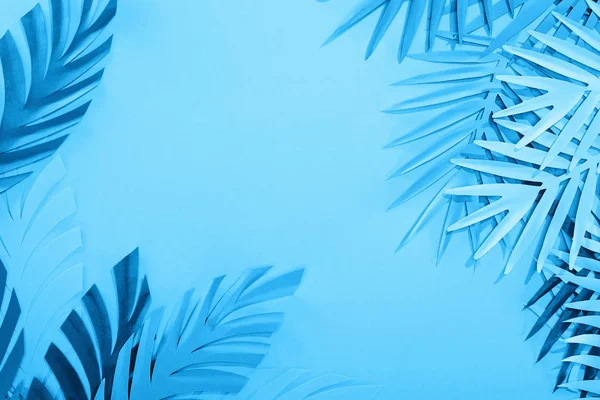 コピースペースを持つ青いミニマルな背景に紙の葉のフレーム — ストック写真