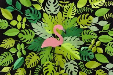 top view of paper cut green leaves with flamingo isolated on black, background pattern clipart
