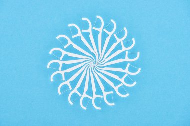 top view of white floss toothpicks isolated on blue  clipart