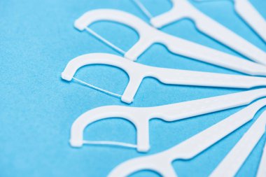 selective focus of white floss sticks isolated on blue  clipart