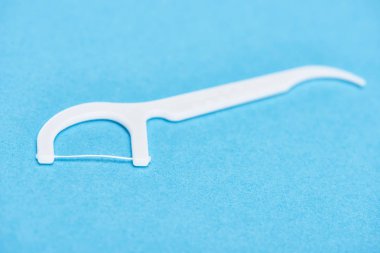 selective focus of white floss stick isolated on blue  clipart
