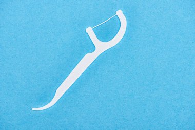 top view of white and plastic floss toothpick isolated on blue  clipart