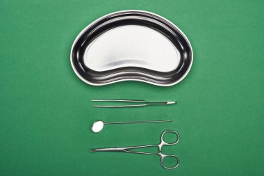 yeşil izole metalik plaka yakın makas ve diş aletleri üst görünümü 