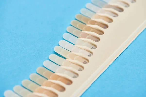 青で隔離された異なる色合いを持つ歯サンプルの選択的焦点 — ストック写真