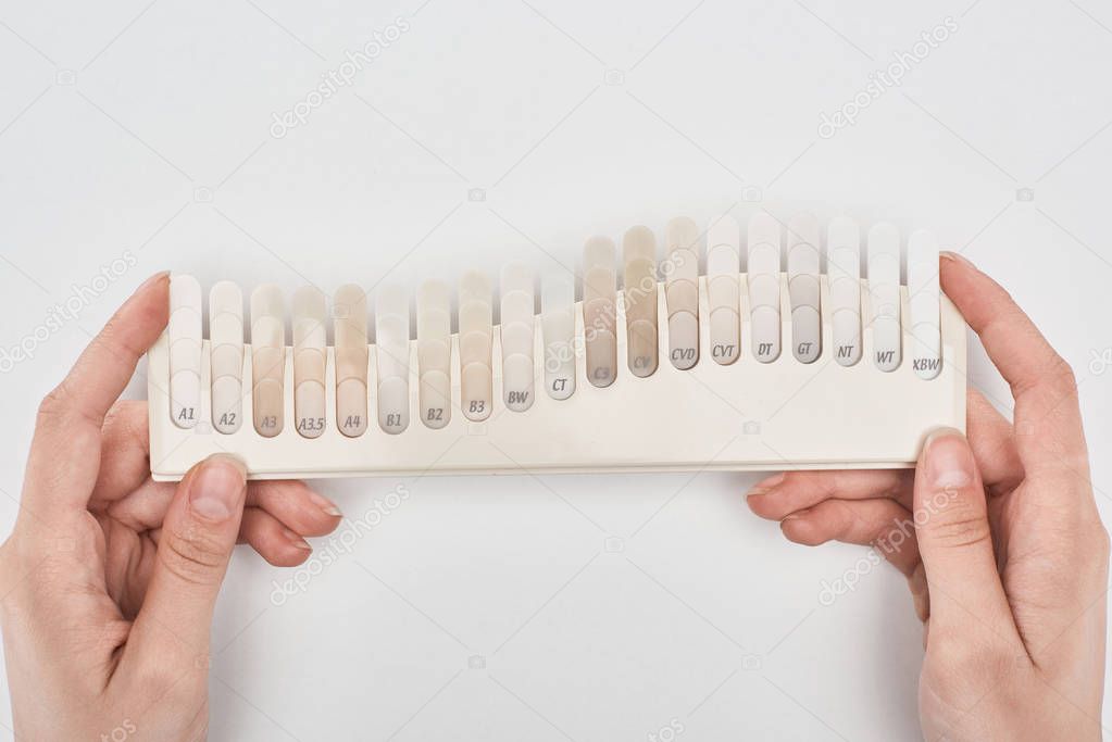 cropped view of woman holding teeth palette isolated on white 