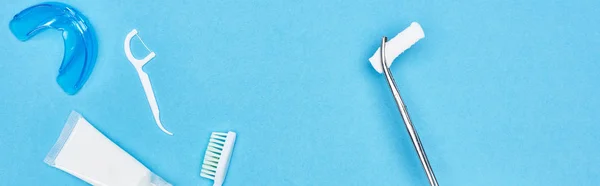 歯磨き粉の近くに綿パッドと青の歯ブラシを持つピンセットのパノラマショット — ストック写真