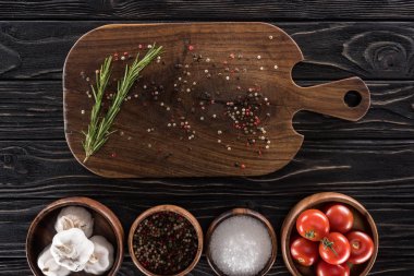 kesme tahtası, kiraz domates, yeşillik, tuz, sarımsak ve baharat üst görünümü 