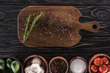 kesme tahtası, kiraz domates, yeşillik, tuz, sarımsak, salatalık ve baharat üst görünümü 
