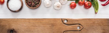panoramic shot of wooden chopping boards, garlics, salt, cherry tomatoes, chili peppers, spices and greenery   clipart