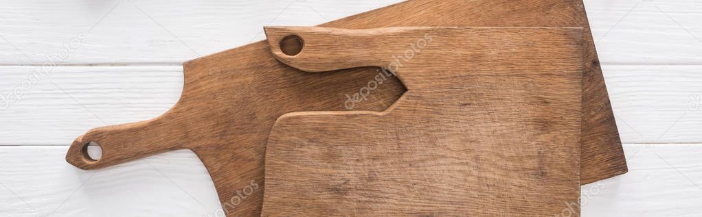 panoramic shot of wooden chopping boards on white table 