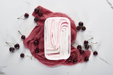 mermer gri arka planda kiraz yakın pembe bez üzerinde lezzetli dondurma üst görünümü