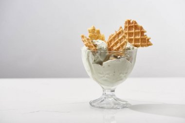 delicious pistachio ice cream with waffles isolated on grey clipart