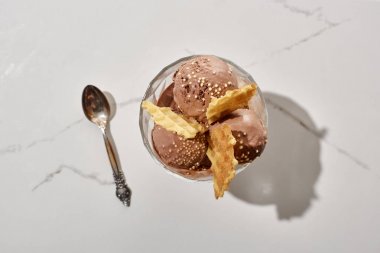 mermer gri arka planda waffle ile kase kaşık ve lezzetli çikolata dondurması üst görünümü