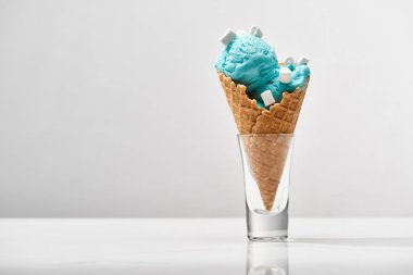 gevrek waffle koni içinde marshmallow ile lezzetli tatlı mavi dondurma gri üzerinde izole