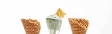 fresh crispy sweet waffle cones and pistachio ice cream isolated on white, panoramic shot clipart