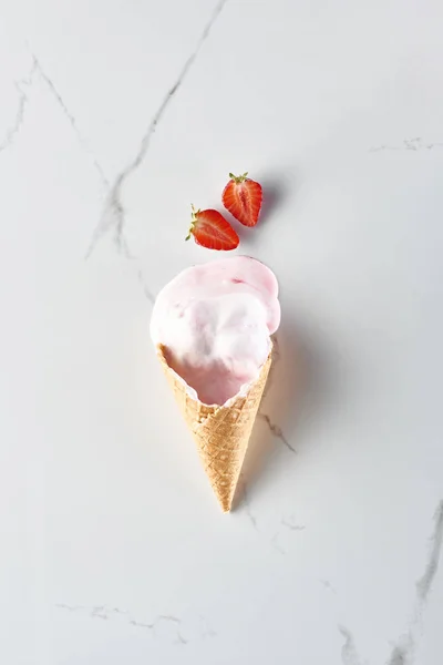 Вид Вкусное Мороженое Вафельном Конусе Рядом Клубникой Мраморном Сером Фоне — стоковое фото