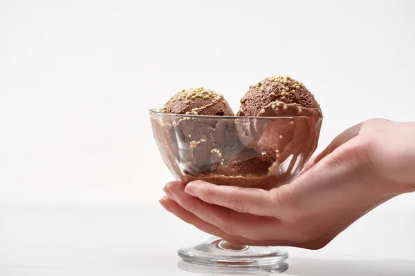 白に隔離されたガラスボウルに美味しいチョコレートアイスクリームを持つ女性の部分的なビュー — ストック写真