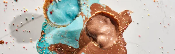 大理石の灰色の背景にワッフルコーンでおいしい溶けたチョコレートとブルーアイスクリームのトップビュー パノラマショット — ストック写真