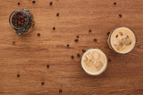 木製のテーブルの上のアイスコーヒーとコーヒーの穀物のトップビュー — ストック写真