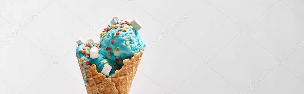 delicious sweet blue ice cream with marshmallows and sprinkles in crispy waffle cone isolated on grey, panoramic shot